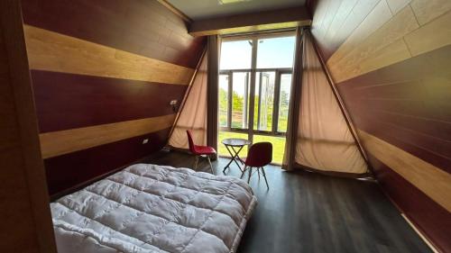 a bedroom with a bed and a large window at Raiyar Resort doodhpathri in Rengazabal
