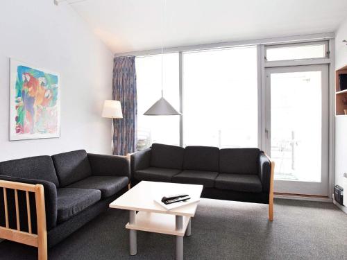 a living room with a couch and a table at Premium apartment with loft in holiday park in Ringkøbing