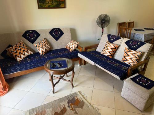 a living room with two couches and a table at Jhvfgt in Dawwār al Ḩajj Aḩmad