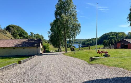 a gravel road next to a barn and a tree at Penthouse in Hobro