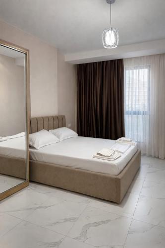 a bedroom with a large bed and a mirror at Adan Luxury Aparthotel in Orikum