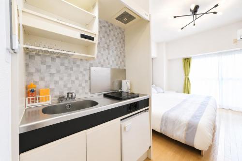 a kitchen with a sink and a bed in a room at 宇都宮ハウスリリー in Utsunomiya