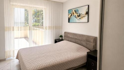 a bedroom with a bed and a large window at Luxury Beachfront Family Apartment in La Pineda