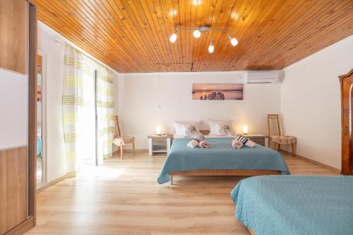 a bedroom with two beds and a wooden ceiling at Apartment Dinka in Kornić