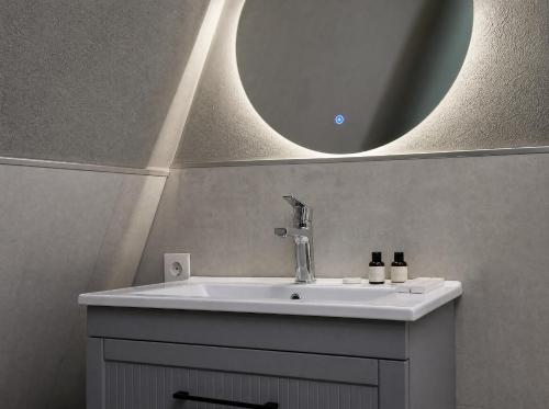 a bathroom with a sink and a mirror at Qafqaz Front Falcon Chalet in Gabala