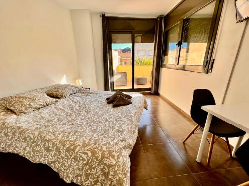 a bedroom with a bed and a table and chairs at Perita Apartamentos in Mataró