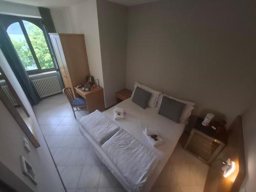 a bedroom with a white bed and a window at Villa Josefine Lake Front beach and Pool in Brenzone sul Garda