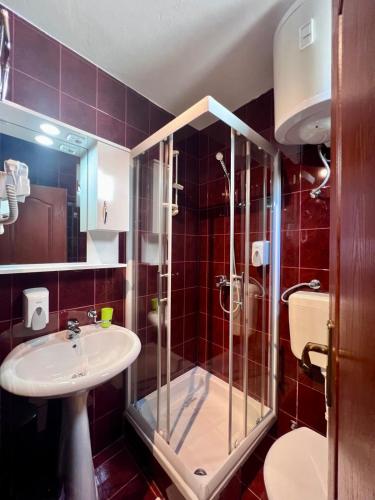 a bathroom with a glass shower and a sink at Hotel Max in Baošići
