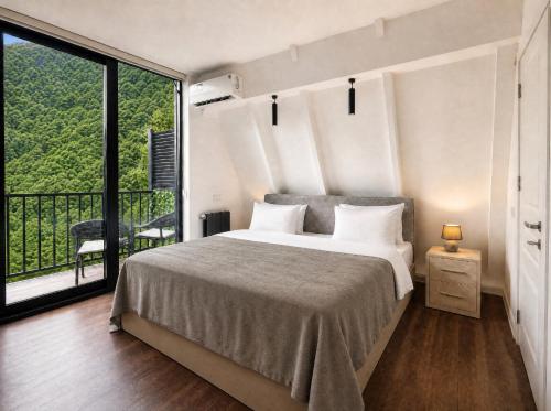a bedroom with a bed and a large window at Qafqaz Front Falcon Chalet in Gabala