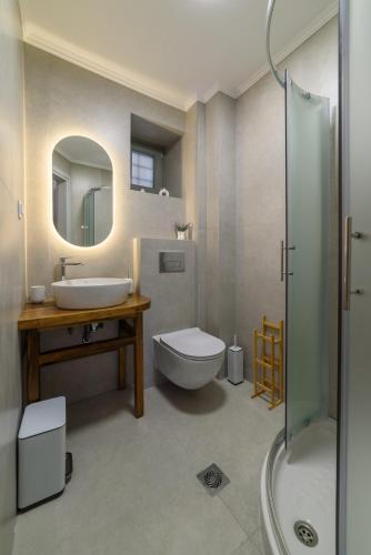 a bathroom with a sink and a toilet and a shower at Orange House - Lower West appartment in Promírion