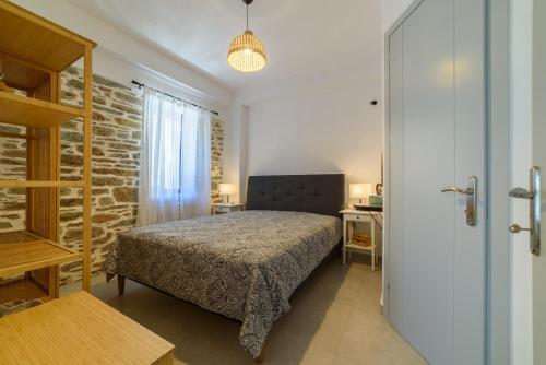 a bedroom with a bed and a brick wall at Orange House - Lower West appartment in Promírion