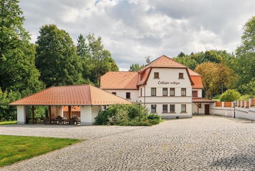 a large white building with a red roof at Penzion Čítkův Mlýn in Šluknov
