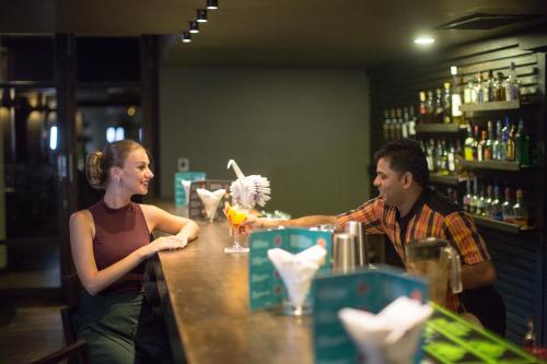 a man and a woman sitting at a bar at Anantaya Resort & Spa Chilaw in Chilaw