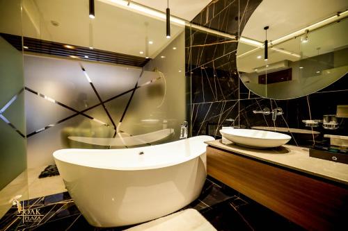 a bathroom with a toilet and a sink and a mirror at Oak Plaza Suites in Kumasi