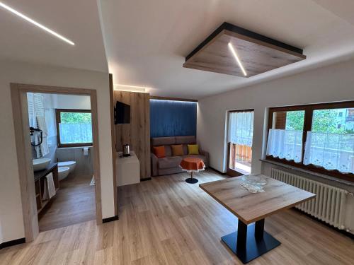 a living room with a table and a couch at Villa L'Aida in Canazei