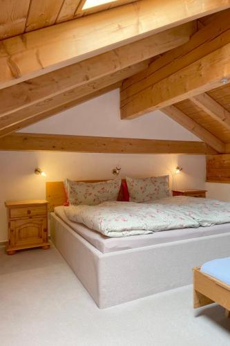 a large bed in a room with wooden ceilings at Apartman Pepa in Bayerisch Eisenstein