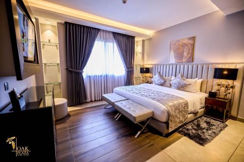 a bedroom with a large bed and a large window at Oak Plaza Suites in Kumasi