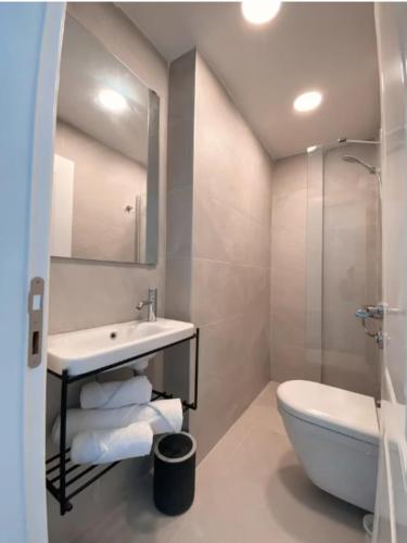 a bathroom with a sink and a toilet and a shower at Amber Butik Otel in Çeşme