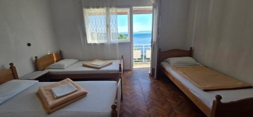 a room with two beds and a window with a view at Simple beachfront rooms Bego in Kraljevica