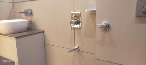 a bathroom with a door with a sink in it at Vista10 in Bhopal