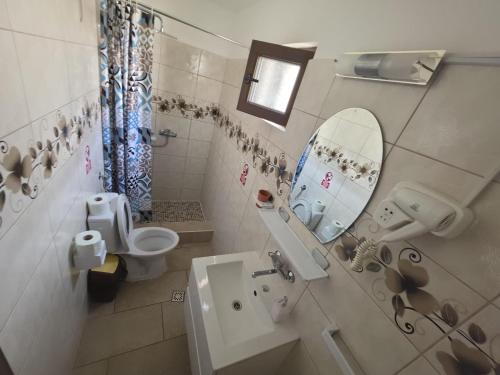a bathroom with a sink and a toilet and a mirror at Vila Lara 2 Mai in 2 Mai