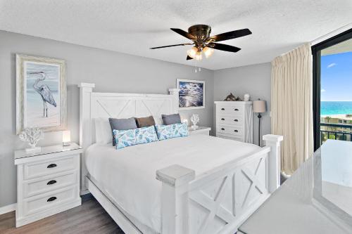 a white bedroom with a bed and a ceiling fan at SunDestin 818 in Destin