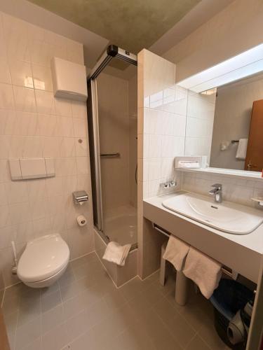 a bathroom with a toilet and a sink and a shower at Hotel Bergheimat in Schönau am Königssee