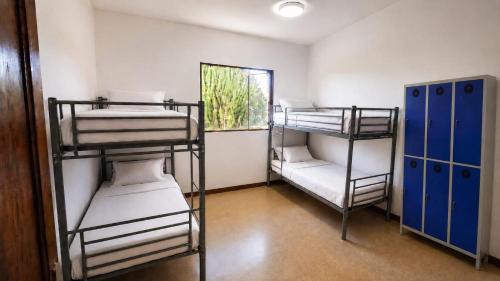 a room with three bunk beds and a window at Guayaba Hostel in Las Lagunas