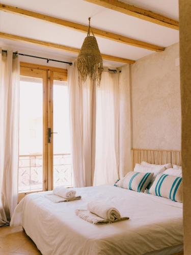 a bedroom with two beds and a large window at The Lodge - Boutique Hotel and Creative Residency in Tamraght Ouzdar