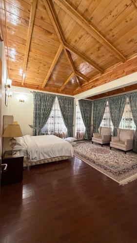 a large bedroom with a large bed and a wooden ceiling at Cascade garden villa in Ayubia