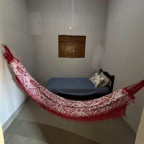 a red hammock in a room with a bed at Praia de Pitangui in Extremóz