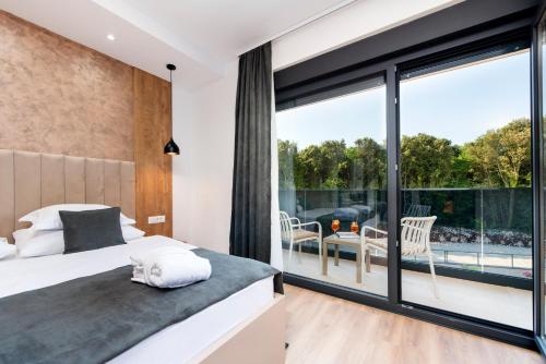 a bedroom with a bed and a large window at Asterias Residence - New Opening 2026 in Rovinj