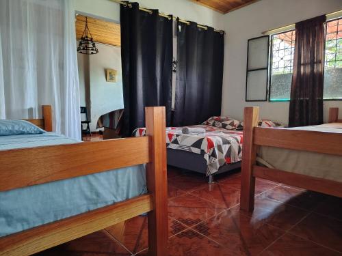 a bedroom with two beds and two windows at Callejón del Sol in Honda