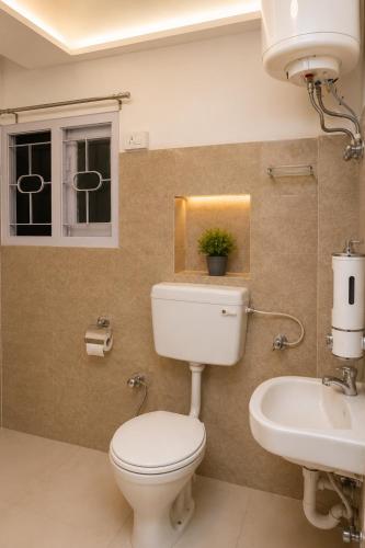 a bathroom with a toilet and a sink at Jannat Hotel - Solan in Solan