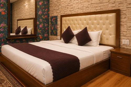 a bedroom with a large bed and a mirror at Jannat Hotel - Solan in Solan