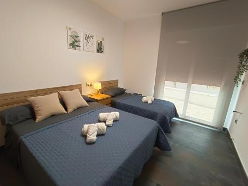 two beds in a room with towels on them at Casa Solaria Córdoba in Guadalcázar