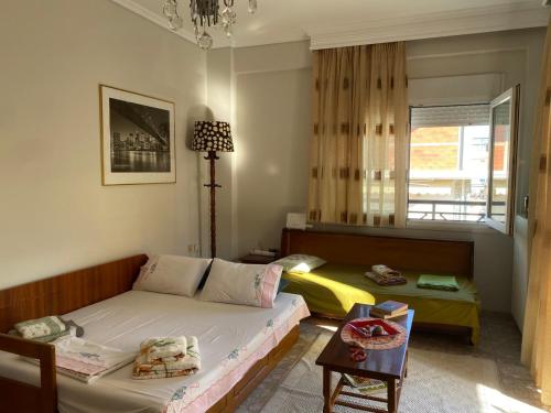 a living room with a bed and a table at Watermelon Home in Nea Moudania