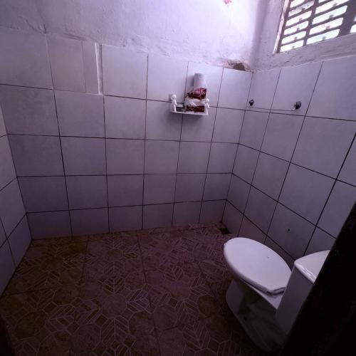 a bathroom with a toilet in a tiled room at Praia de Pitangui in Extremóz