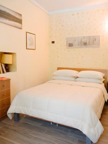 a bedroom with a large white bed with white pillows at Villa Valeria in San Floro
