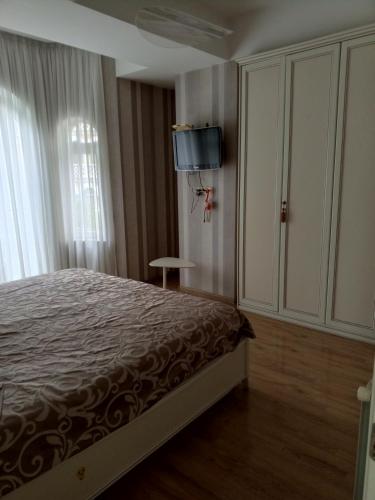 a bedroom with a bed and a tv on the wall at 19 Rustaveli Ave in Batumi