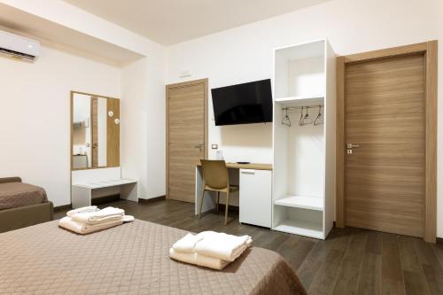 a hotel room with a bed and a desk with a computer at kalispera in Cinisi