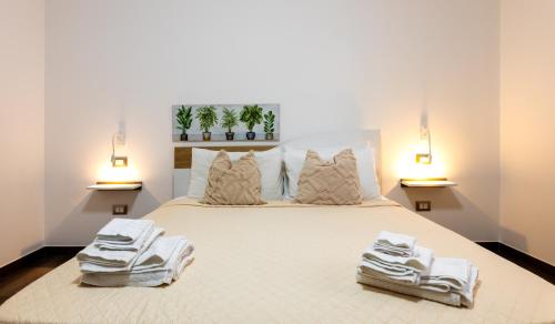 a bedroom with a large bed with towels on it at kalispera in Cinisi