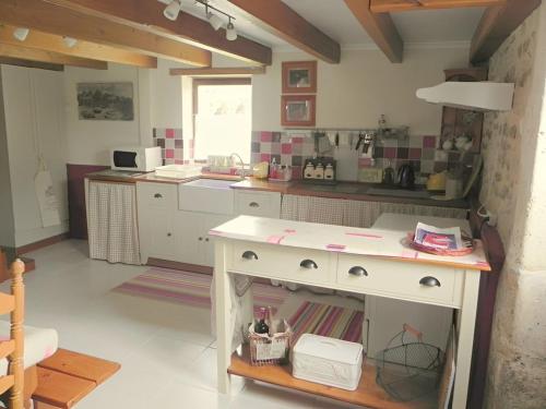 a kitchen with a white counter in a room at Le Tilleuil in Combiers