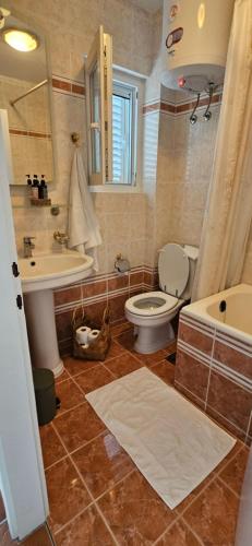 a bathroom with a toilet and a sink and a tub at Apartment with private pool in Njivice