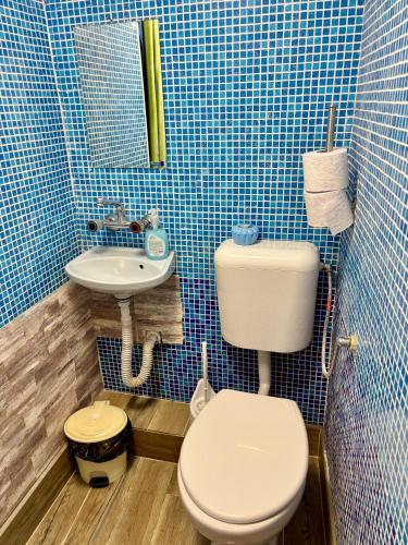 a blue tiled bathroom with a toilet and a sink at hostel FARA in Nesebar