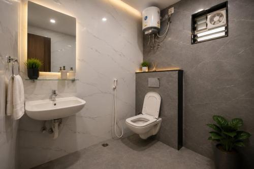 a bathroom with a white toilet and a sink at Hotel cressida green palace - near redisson squar in Indore