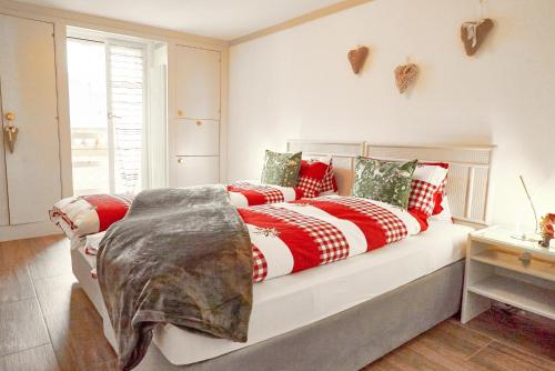 a bed with red and white blankets and pillows at Double Room by Interlaken. Parking in Därligen