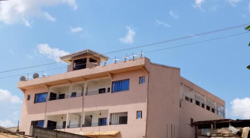 a building with a balcony on top of it at TCHASSHOUSE Motel in Yaoundé