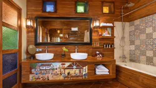a bathroom with two sinks and a mirror and a tub at Nan Seasons Boutique Resort in Nan