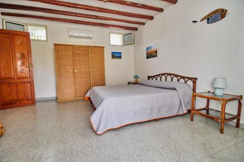 a bedroom with a bed and a wooden door at House La Pennata - sea view in Malfa